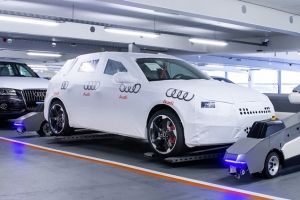 Roboty transportują samochody w fabryce Audi